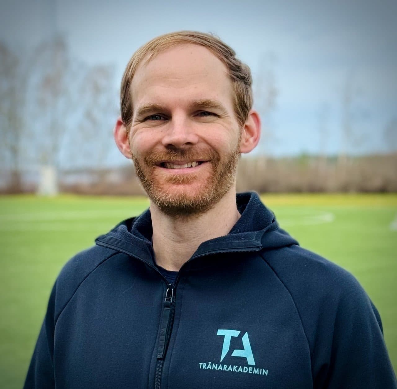 Jakob Dehnisch, grundare av Tränarakademin, i tröja med skolans logotyp