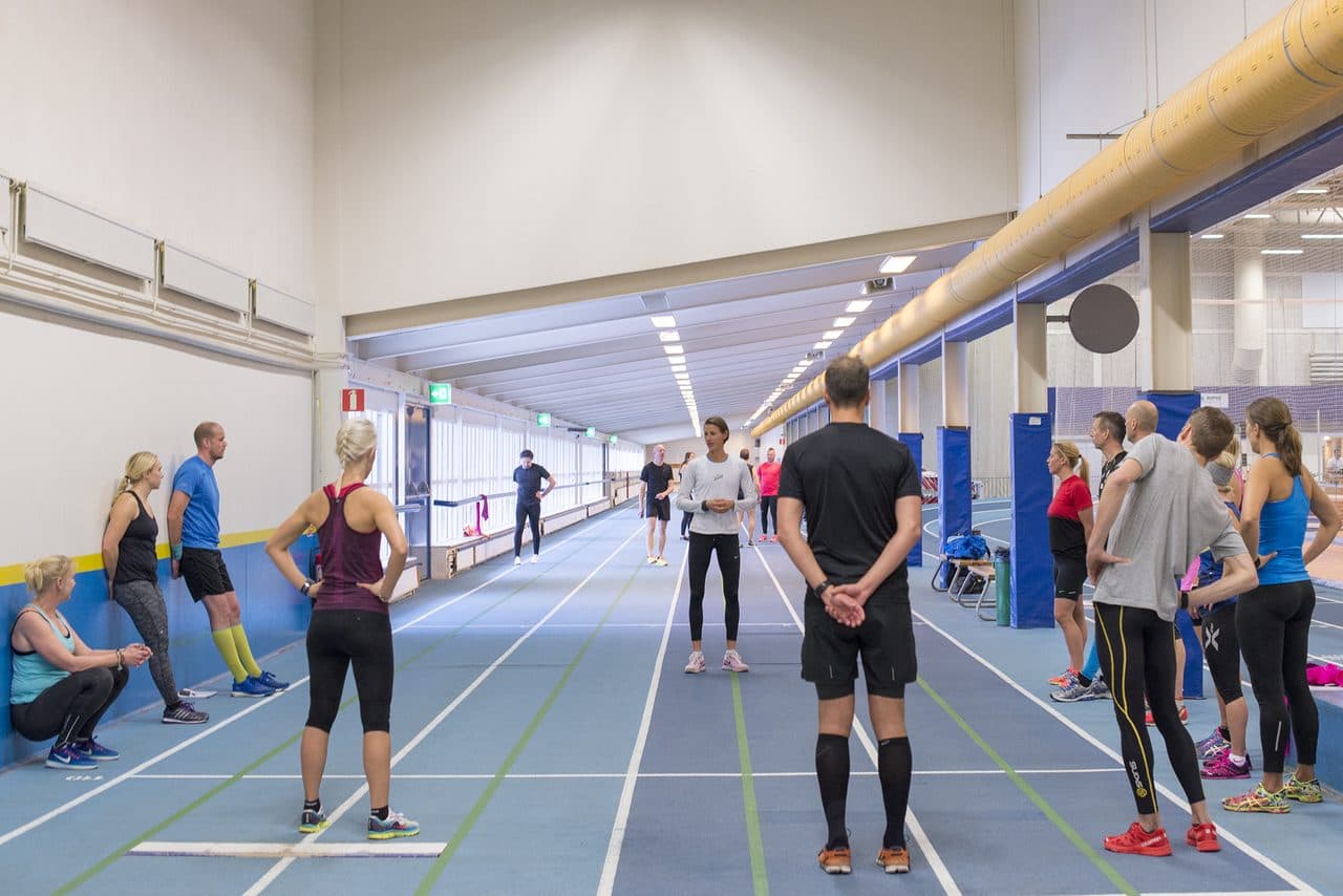 Studenterna övar löpteknik på banan medan Malin instruerar