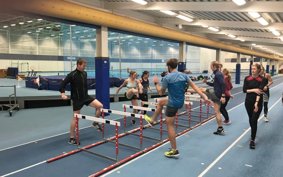 Löpcoachstudenter övar häcklöpning på inomhusbanan på Bosön