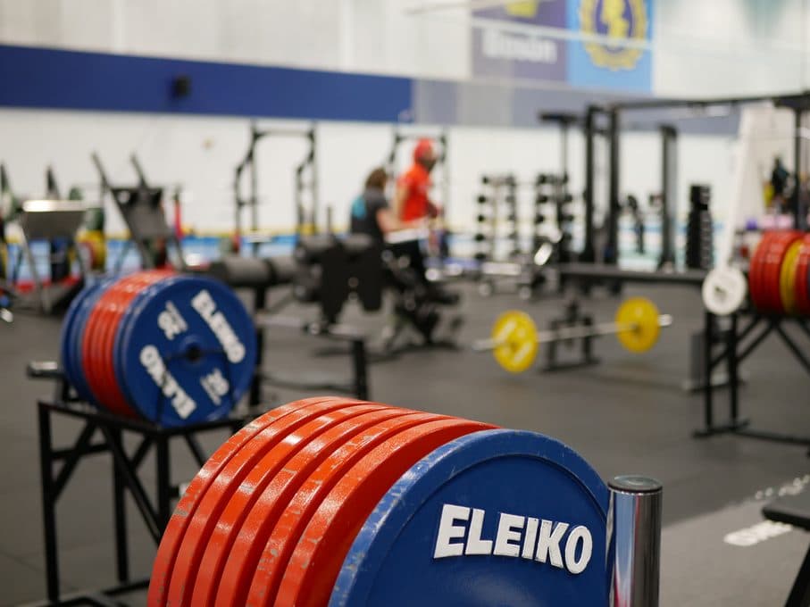 Röda och blå Eleiko-viktskivor med Framgångshallen i bakgrunden