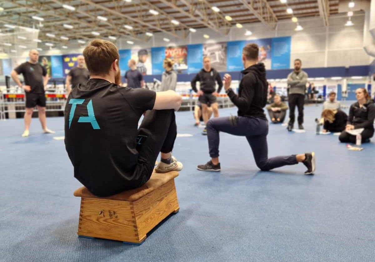 Lärare som visar en split squat under vår PT-utbildning